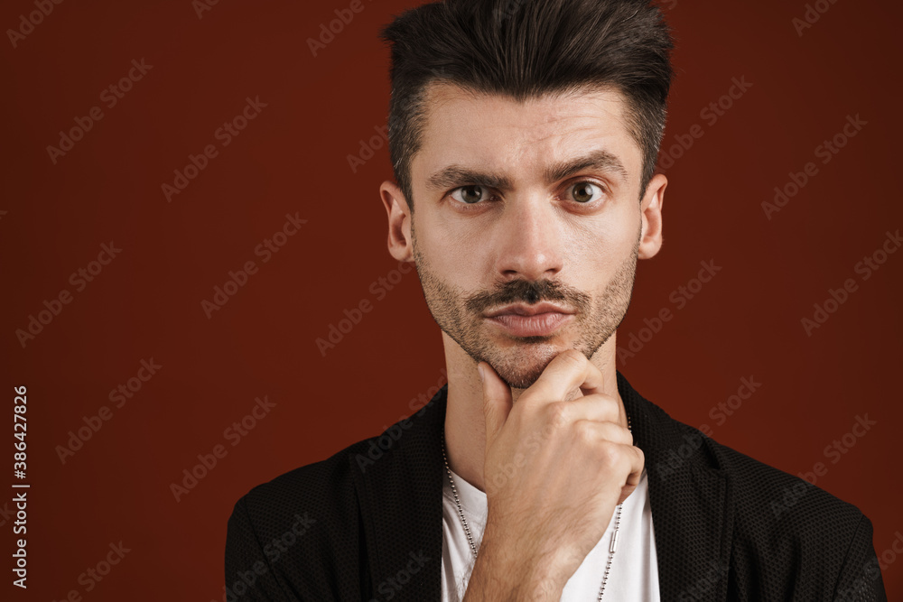 Photo of confident man looking at camera and touching his chin Photo of confident man looking at camera and touching his chin