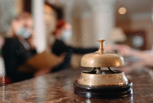 Check in hotel. receptionist at counter in hotel wearing medical masks as precaution against virus. Young woman on a business trip doing check-in at the hotel