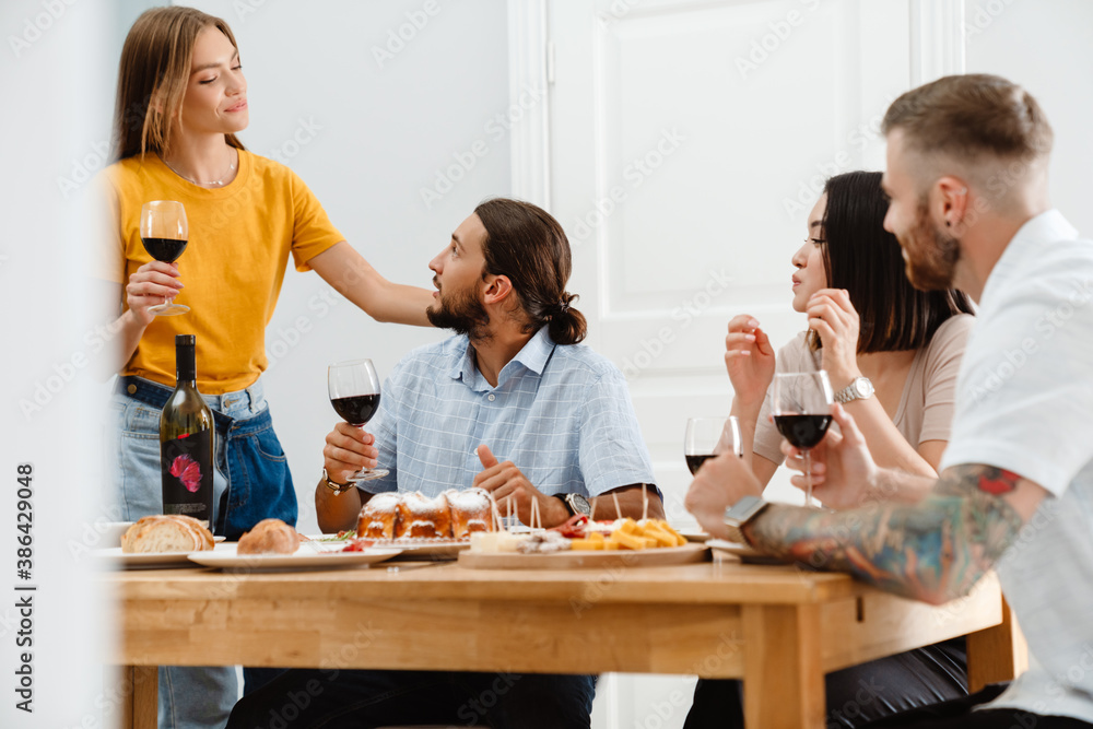 Image of multinational friends talking each other while having lunch Image of multinational friends talking each other while having lunch