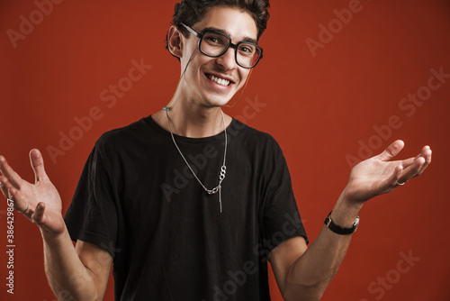 Confused young hipster man standing isolated photo