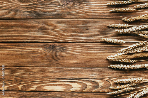 top view of wheat ears border on wooden background