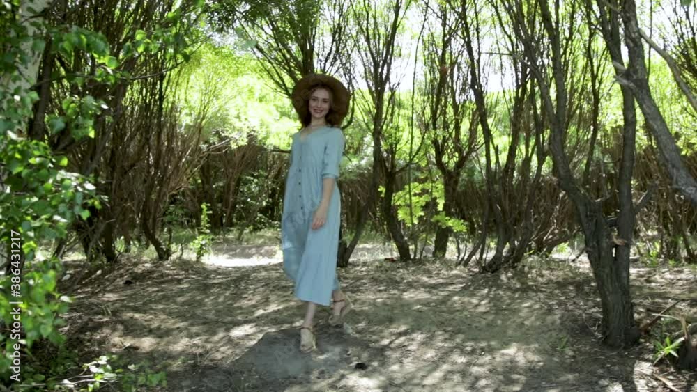 A young attractive girl in a hat running in a summer Park at sunset, in the woods. Beautiful woman enjoying the nature outdoors. A young attractive girl in a hat running in a summer Park at sunset, in the woods. Beautiful woman enjoying the nature outdoors.