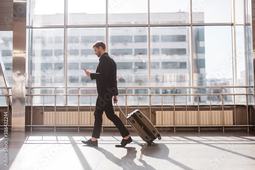 Man walking through the airport with the luggage