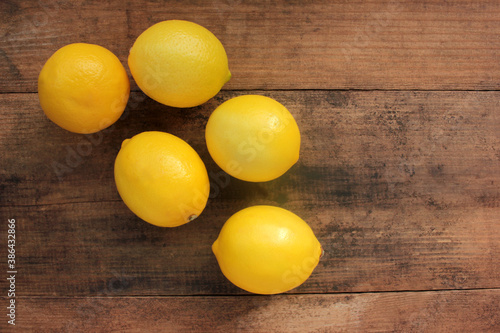 Fresh yellow lemons on wooden background. Flat lay, copy space