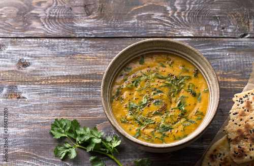 Indian lentil masurdal soup with turmeric, ginger and herbs, top view, space
