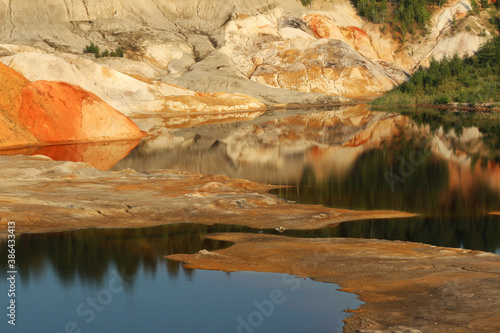 Fototapeta Naklejka Na Ścianę i Meble -  quarries in the place of mining and red refractory clay against the backdrop of red clay mountains and quarries