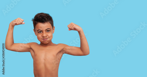 swarthy little child stands in a sports pose, advertising for sports sections, close-up, blue background