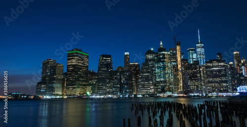 Night photo of glowing skyscrapers and a view of Manhattan Bay. Long duration. Panoramic photo. The splendor of the city at night.
