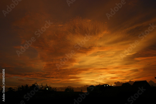 Dusk with yellow clouds. Silhouette of a building roof