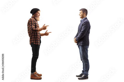 Full length profile shot of a bearded guy standing and talking to a man