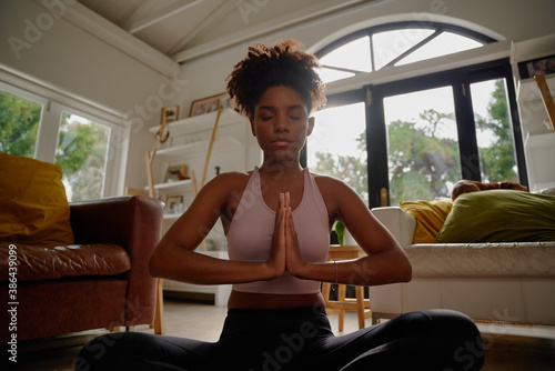 Portrait of young african yogic woman practicing yoga in namaste position and closed eyes photo