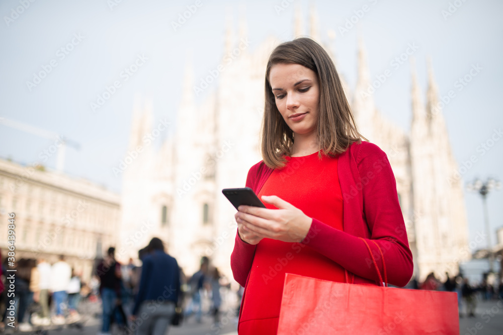 Fototapeta premium Smiling young woman shopping in Milan, Italy