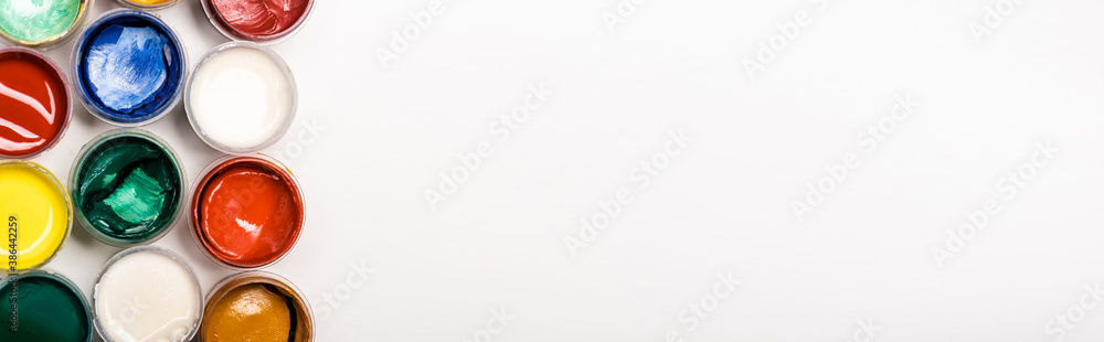 top view of colorful Gouache paints on white background, panoramic shot top view of colorful Gouache paints on white background, panoramic shot
