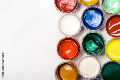 top view of colorful Gouache paints on white background