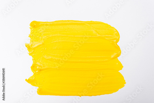 top view of abstract colorful yellow paint brushstrokes on white background