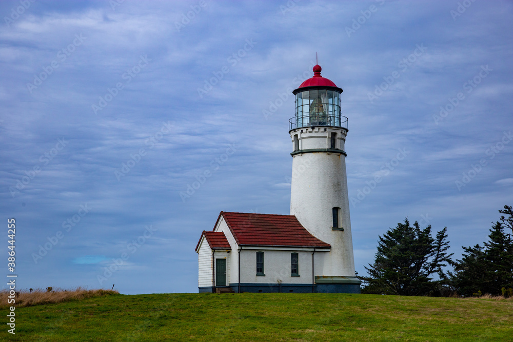 red and white lighthouse on a grassy hill red and white lighthouse on a grassy hill
