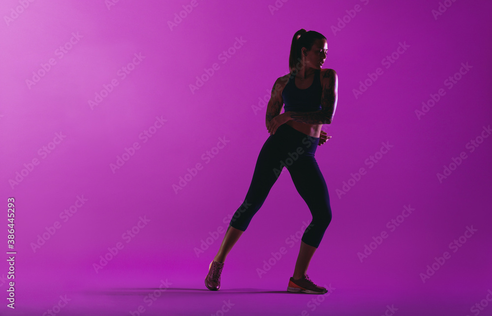 Fitness woman working out on purple background