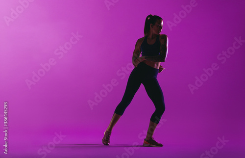 Fitness woman working out on purple background