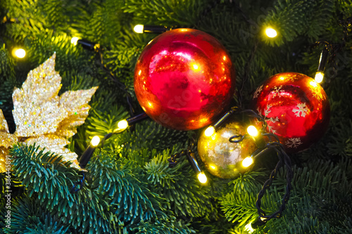 Festive New Year background, Christmas tree garlands, balls and toys. Illumination, green branch, xmas