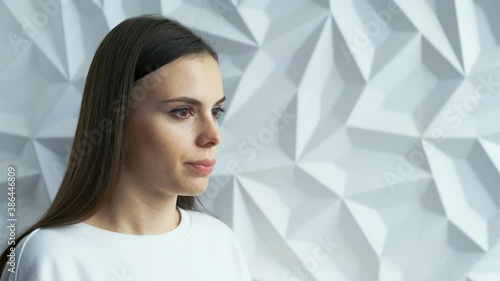 A beautiful brunette girl in white as a doctor coughs, sneezes, perhaps she is infected with covid, against a white volumetric background