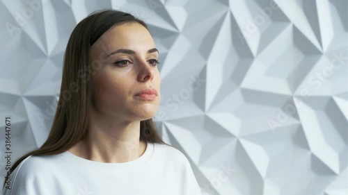 A beautiful brunette girl in white as a doctor coughs, sneezes, perhaps she is infected with covid, against a white volumetric background
