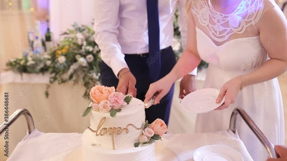newlyweds cut the wedding cake, close-up. The bride and groom cut the wedding cake. newlyweds cut the wedding cake, close-up. The bride and groom cut the wedding cake.