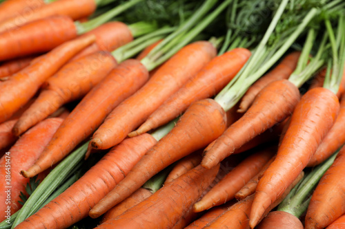 Pile of tasty raw carrots as background, closeup