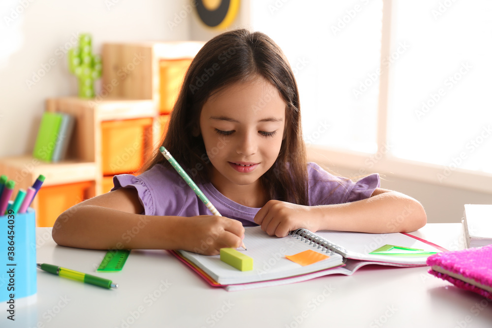 Little girl doing homework at table indoors Little girl doing homework at table indoors