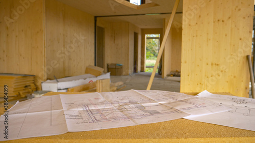 CLOSE UP: Blueprints and other plans lie on a makeshift desk in a CLT house.