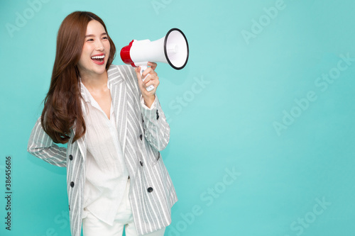 Fotografie Young Asian woman holding megaphone isolated on green background, Speech and ann