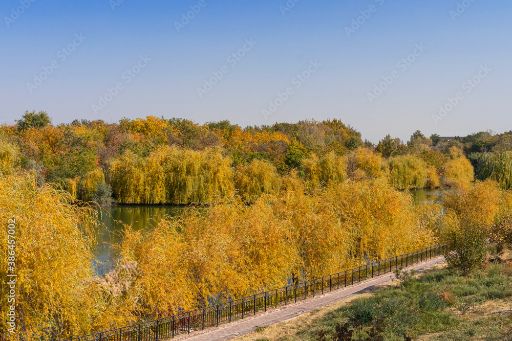 Autumn landscape. Lake in the park in autumn. Reflections in the water. Autumn trees and plants. Lake. Gold autumn. Yellow, orange, red, brown, green leaves. Blue sky Autumn landscape. Lake in the park in autumn. Reflections in the water. Autumn trees and plants. Lake. Gold autumn. Yellow, orange, red, brown, green leaves. Blue sky