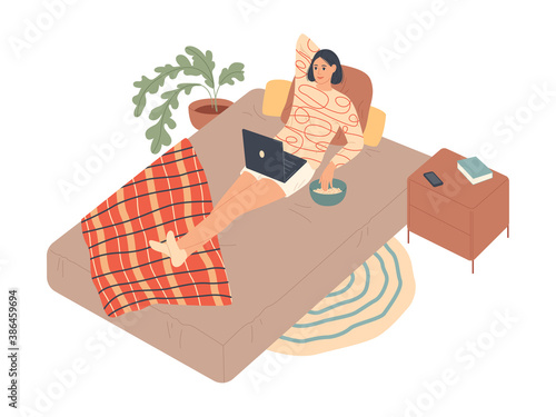 Woman lies on the bed and watches series on laptop.