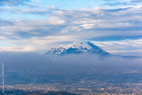 Chimborazo and Carihuayrazo volcanoes at sunrise with the city of Ambato photo