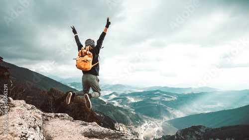 Fototapeta Naklejka Na Ścianę i Meble -  Successful hiker man jumping on the top of the mountain - Successful, business and sport concept.