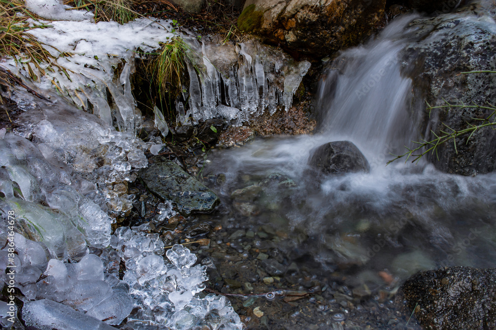 Tiny waterfall in the mountains surrounded by frozen stalactites during winter season in Esquel, Patagonia, Argentina Tiny waterfall in the mountains surrounded by frozen stalactites during winter season in Esquel, Patagonia, Argentina