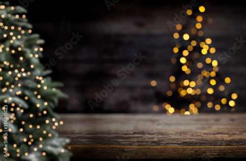 blurred background of xmas tree lights and wall wooden board and free place