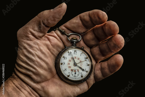 Hand holding a worn vintage pocket watch