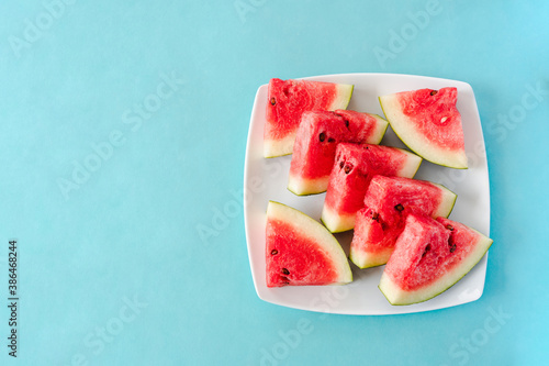 Water melon slices on a plate on blue background