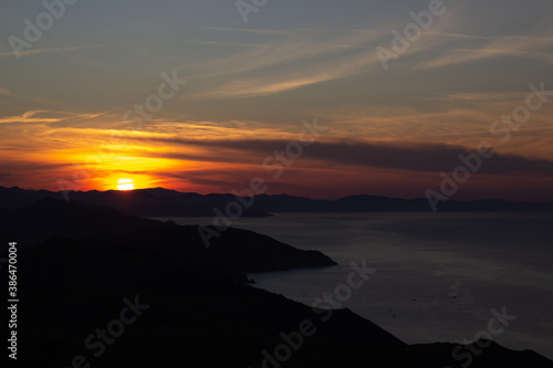 Sunset at dusk with mountains and the sea