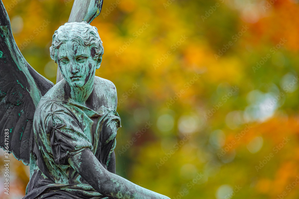 Statue of ancient beautiful winged angel in downtown park of Potsdam in beginning of Autumn at sunset, Germany Statue of ancient beautiful winged angel in downtown park of Potsdam in beginning of Autumn at sunset, Germany
