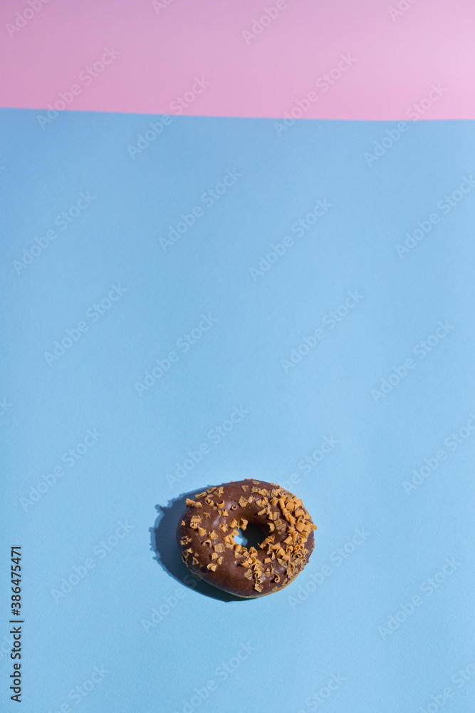 Trendy sunlight. Doughnut on bright light blue turquoise background. Minimal summer concept. Pop art style. Chocolate donut. Trendy sunlight. Doughnut on bright light blue turquoise background. Minimal summer concept. Pop art style. Chocolate donut.