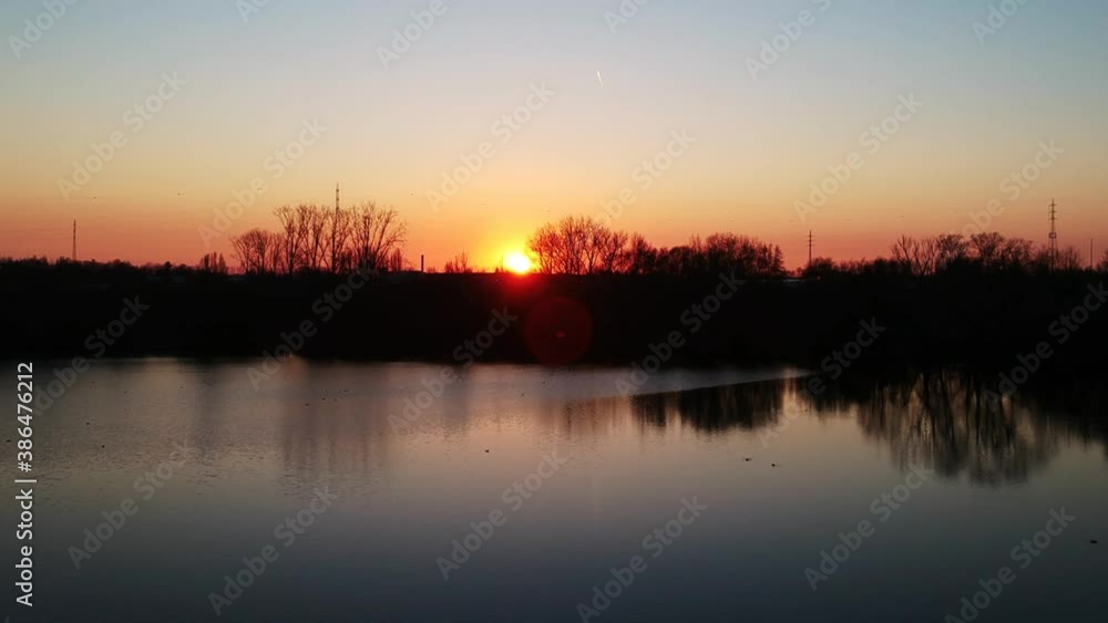 The red-blue sky of a sunset captured over a relaxingly still pond. The red-blue sky of a sunset captured over a relaxingly still pond.