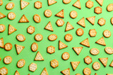 Delicious crackers on light green background, flat lay