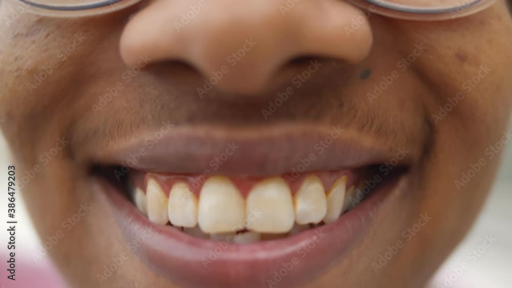 Close up of happy african man smiling with toothy smile over blurred background Close up of happy african man smiling with toothy smile over blurred background