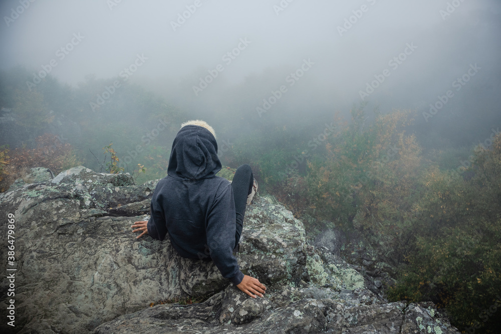 person in the mountains, overlooking a forest person in the mountains, overlooking a forest