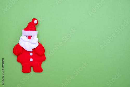 Santa Claus on green background and copy space for text. Cute santa claus made of cloth.