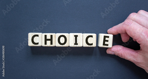 CHOICE word written on wood block. Male hand. CHOICE text on dark background for your desing, concept. Copy space.
