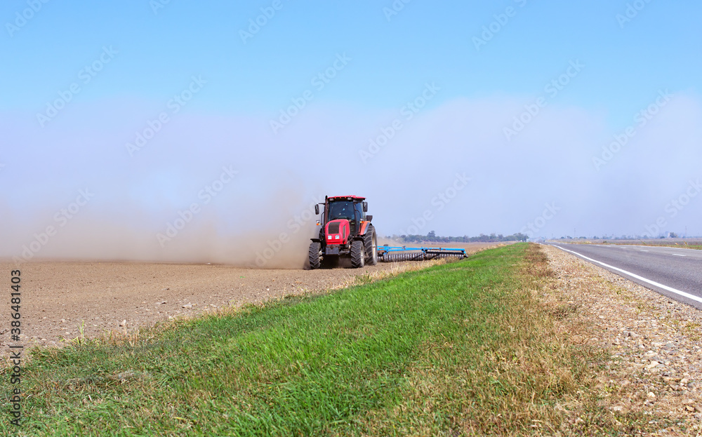 Fototapeta premium disking the field after harvest for better fertilization of the soil and getting rid of weeds