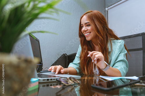 mujer joven empresaria emprendimiento trabajando en escritorio oficina sonriente feliz realizada photo