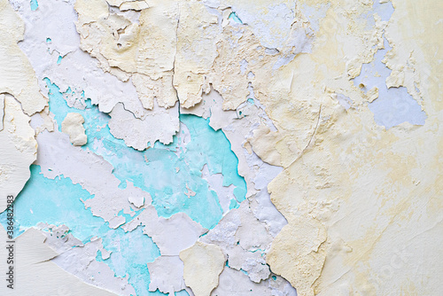 Colorful background. Layers of peeling plaster of different colors. Yellow and blue